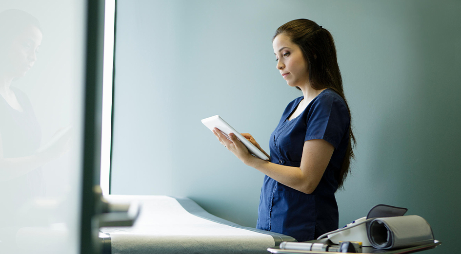 Nurse-looking-at-tablet-in-exam-room_wide-1