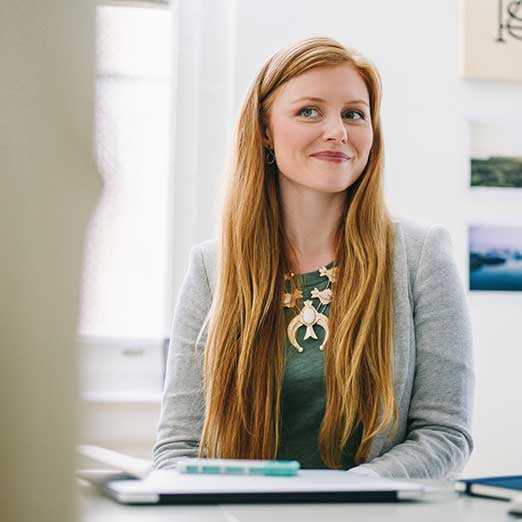 Woman-smiling-sitting-at-desk_wide